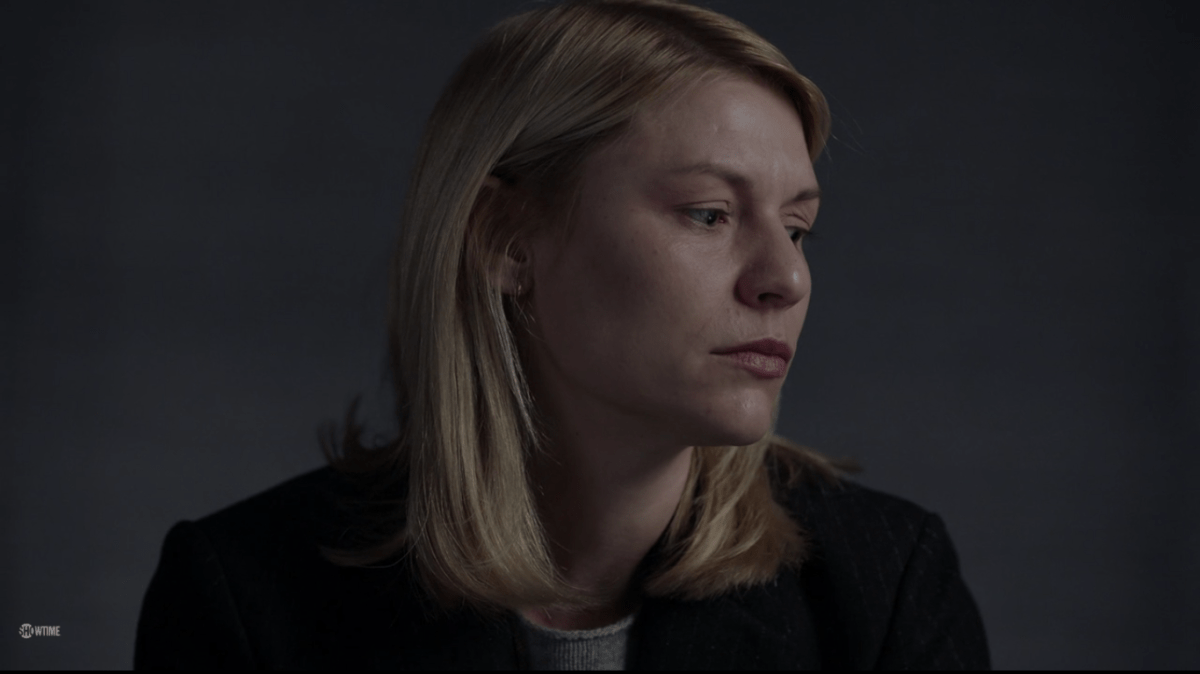 A woman in a blazer (Carrie) looks sadly off to her left.