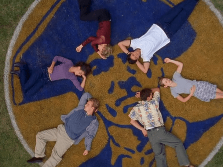 Six people (Pacey, Andie, Dawson, Chris, Jen, Joey) sleep on the football field in a circle.