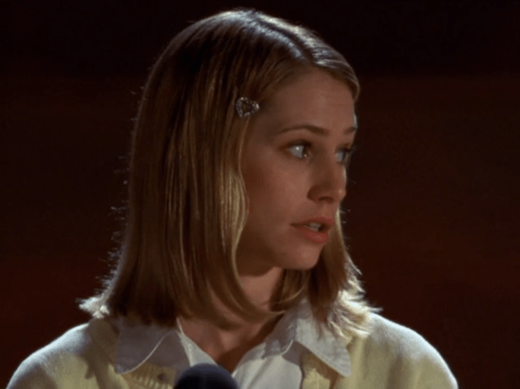 Andie looks to the side, revealing a heart-shaped barrette.