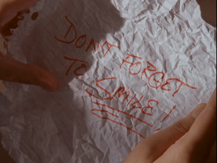 Image: written, crumpled note that says "Don't forget to smile!"