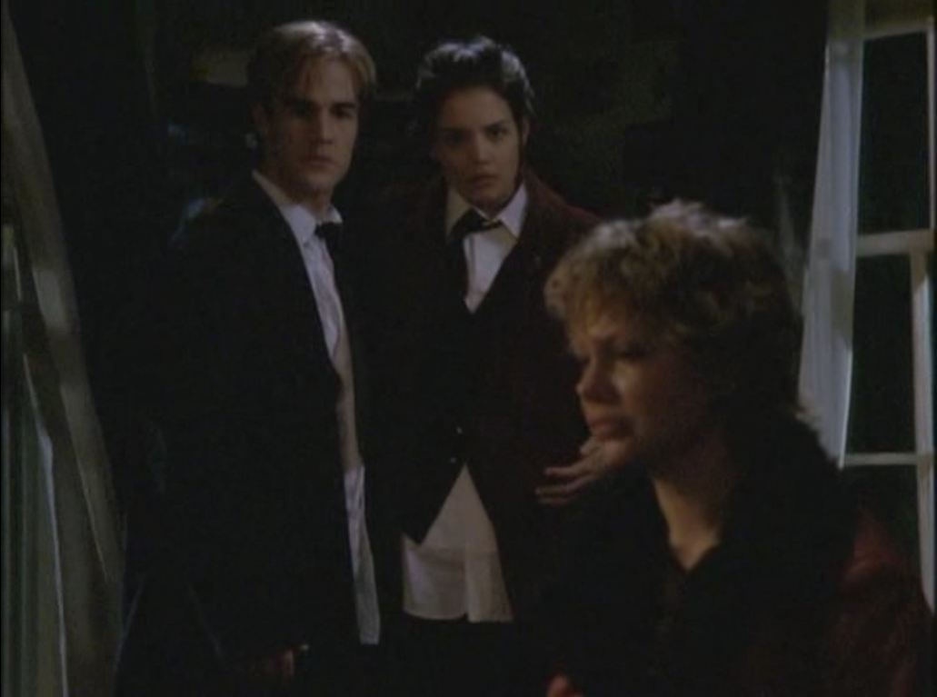 Jen sits in the foreground looking sad and damp; Joey and Dawson, in formalwear, stand side-by-side looking at her in the background.