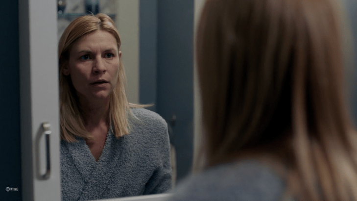 Carrie's face, looking scared and determined, is reflection