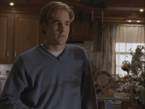 Dawson stands in his kitchen with symmetrical bangs going off to each side of his forehead.