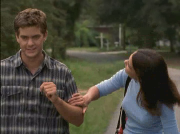 Joey and Pacey are walking down the street. Joey is touching Pacey's arm.