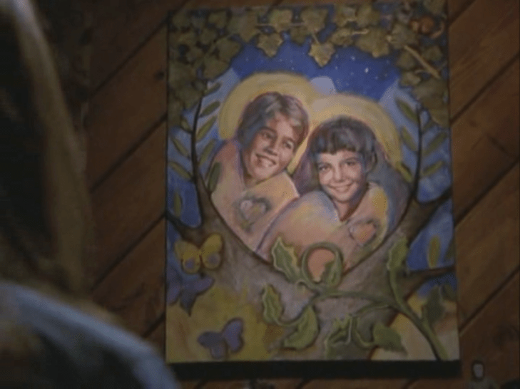 A cheesy painting of Dawson and Joey with halos around their head and a heart-shaped ivy wreath around them.