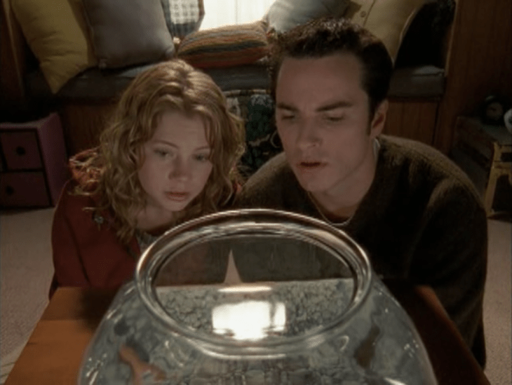 Jen and Jack stare at a fishbowl.