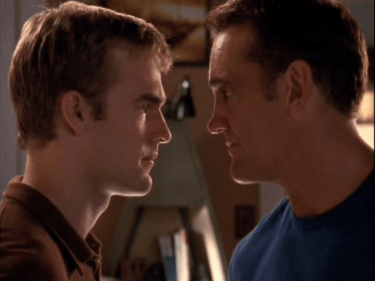Closeup of two men (Dawson, left; Mitch, right) facing each other with their noses centimeters apart.