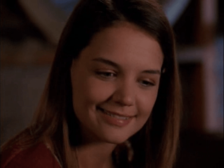 A young white woman with brown hair (Joey) looks dreamily off to the side, smiling.