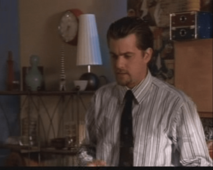 Pacey with greased-back hair, in a shirt and tie.