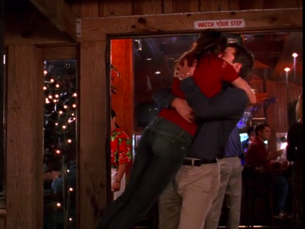 Pacey picks up Joey and holds her around the torso, mid-spinning her around.