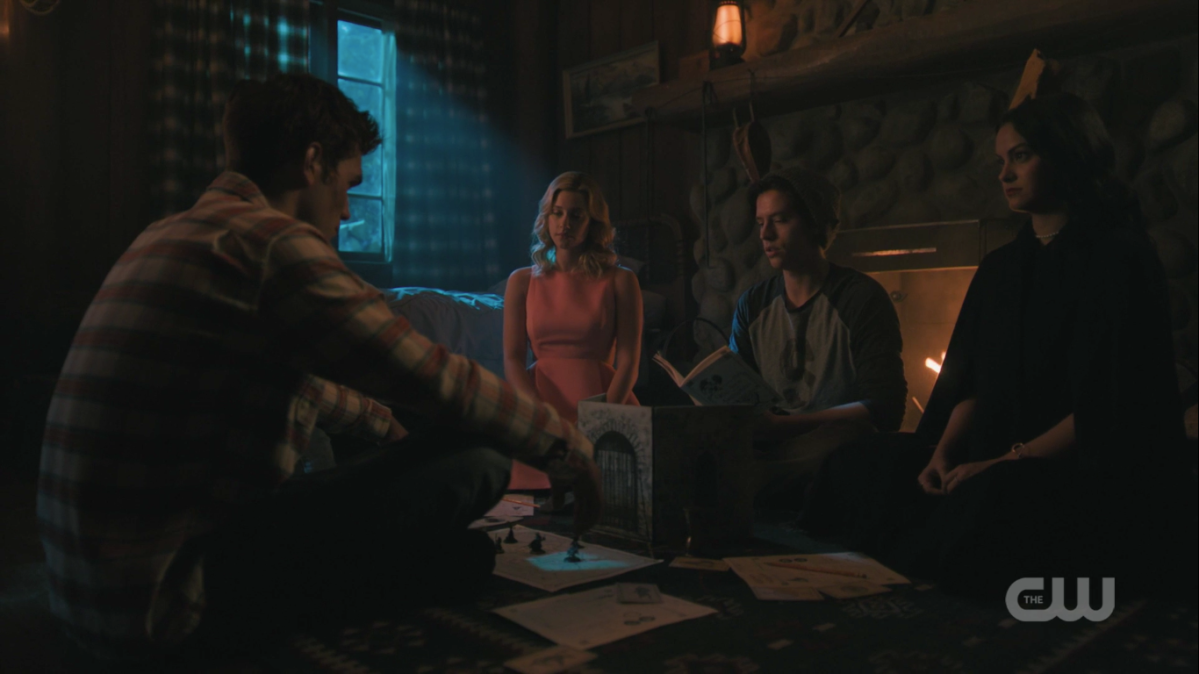 Archie, Betty, Jughead, and Veronica sit by a fireplace playing G&G.