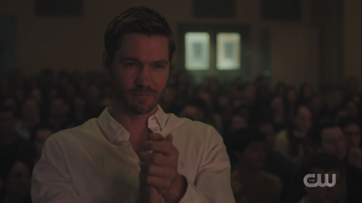 A blonde man with stubble stands in an otherwise seated crowd, clapping. It is Chad Michael Murray