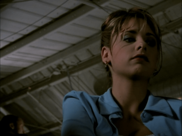 Buffy is seen in a darkened balcony, looking below her.