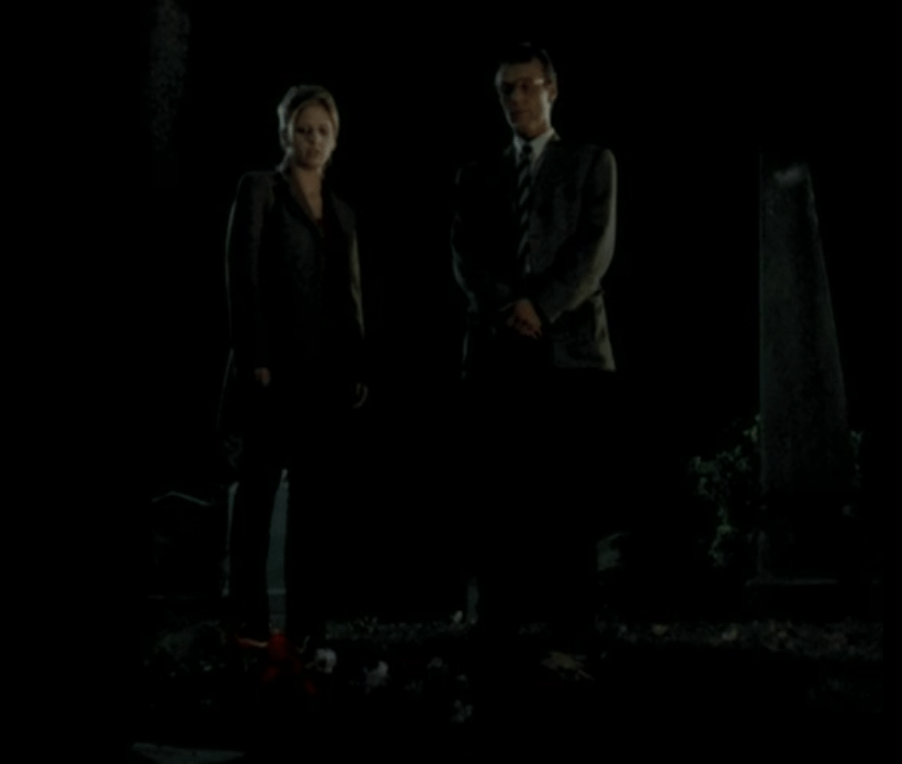 Buffy and Giles stand in the cemetery.