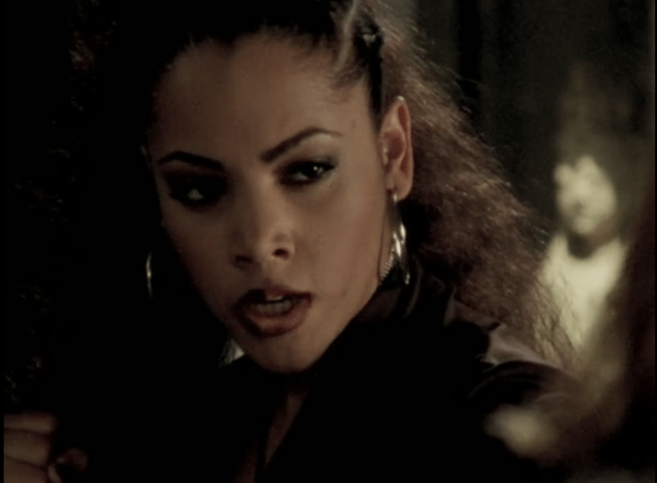 A young woman with hoops and lip liner makes a face, fists held up. (This is Kendra)