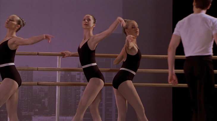 Image description: Jody stands at the barre facing the wrong direction opposite of two other dancers.